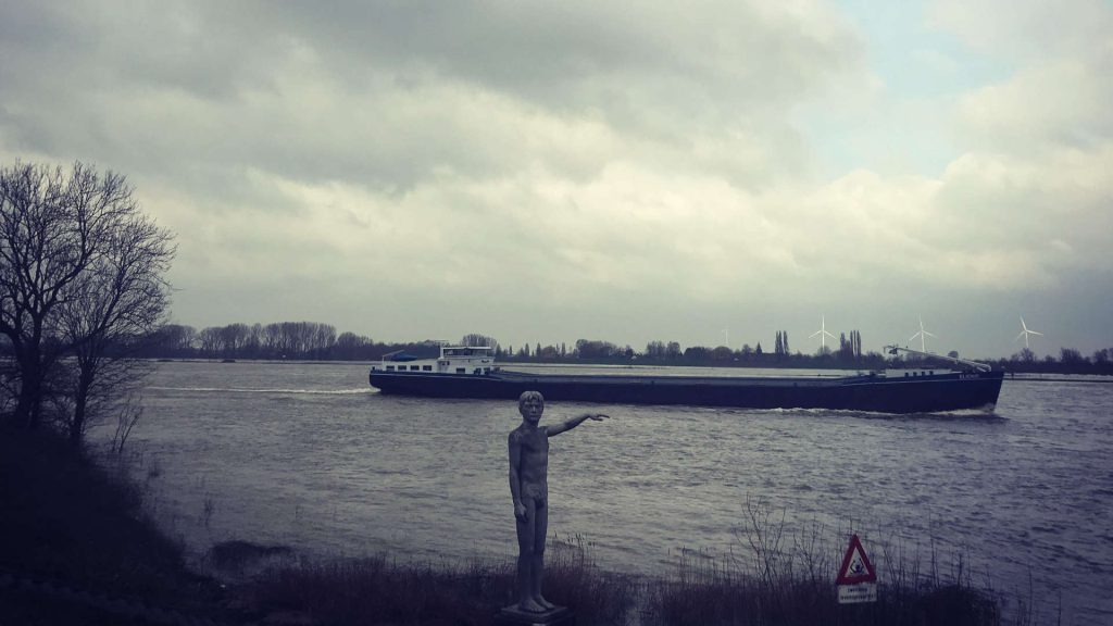 beeld-wijst-vrachtboot-weg-over-waal